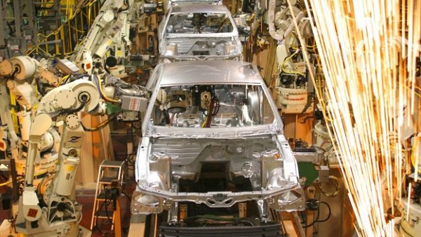Robôs construindo carros